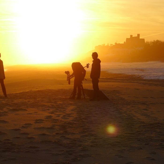 Film crew silhouetted on a Southampton beach at sunrise